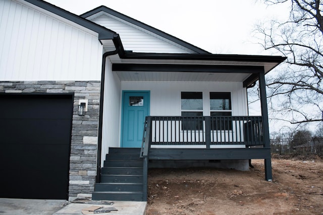 view of exterior entry featuring a porch and stone siding