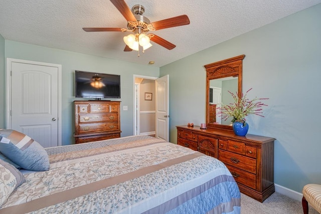 bedroom with light carpet, ceiling fan, a textured ceiling, and baseboards