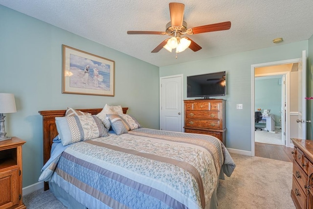 bedroom with light colored carpet, ceiling fan, a textured ceiling, and baseboards