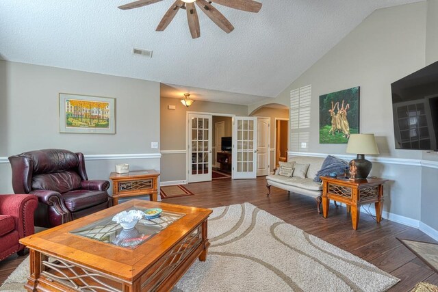 living room with arched walkways, french doors, visible vents, dark wood-type flooring, and vaulted ceiling