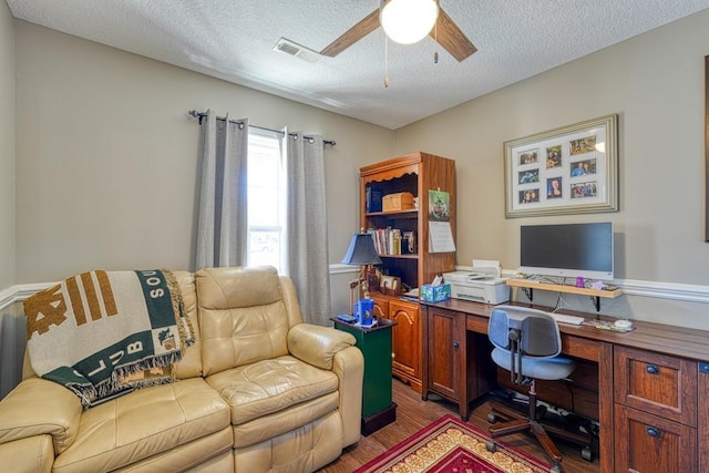 office area featuring dark wood-style floors, ceiling fan, and a textured ceiling