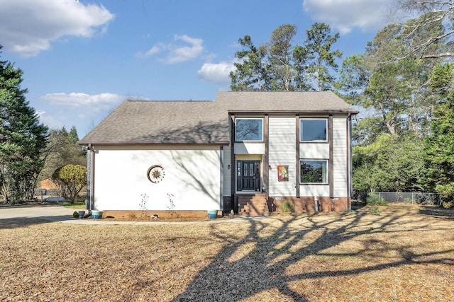 view of front of home with crawl space, fence, a front lawn, and roof with shingles