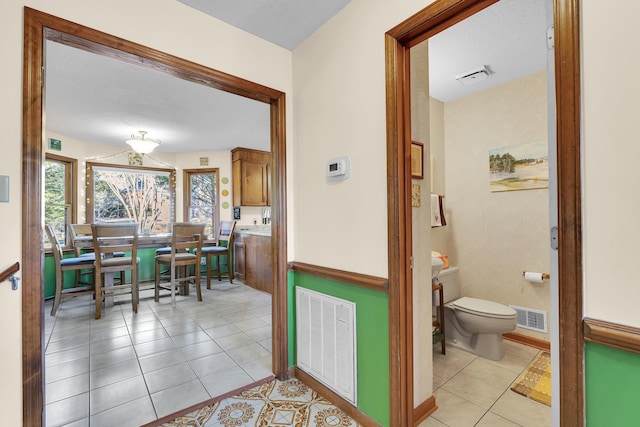 interior space with light tile patterned floors, visible vents, and baseboards