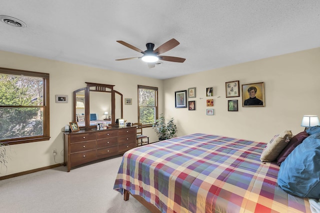 bedroom featuring light carpet, baseboards, visible vents, ceiling fan, and a textured ceiling