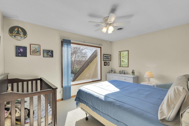 carpeted bedroom featuring baseboards, visible vents, and a ceiling fan