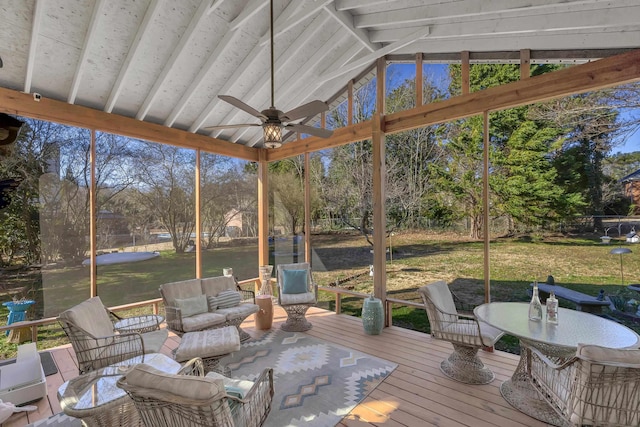 sunroom with a ceiling fan, a water view, plenty of natural light, and lofted ceiling with beams