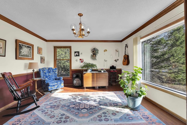 interior space featuring a textured ceiling, a notable chandelier, wood finished floors, and crown molding