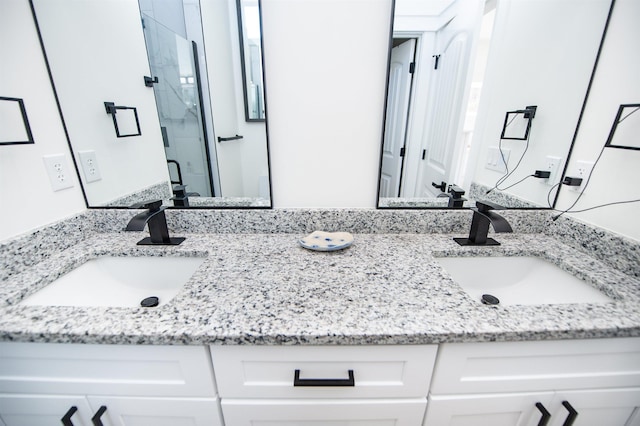 bathroom featuring a marble finish shower and vanity