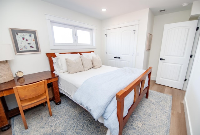 bedroom featuring a closet, visible vents, wood finished floors, and recessed lighting