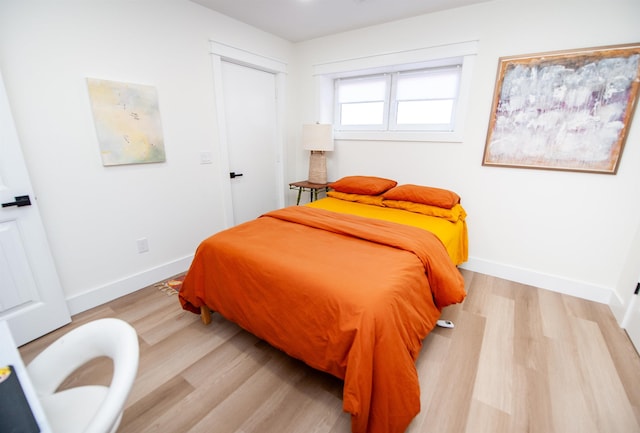 bedroom featuring light wood-style flooring and baseboards