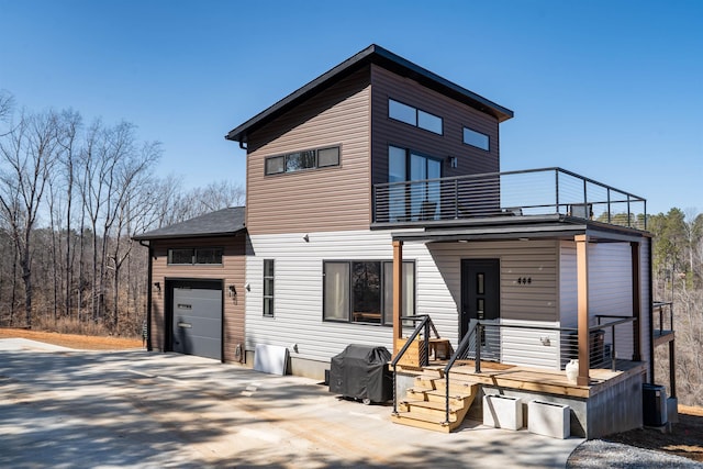 view of front of property featuring a balcony, driveway, and an attached garage