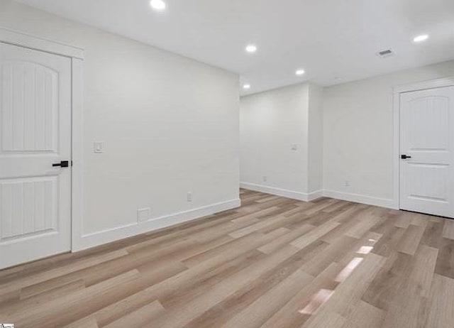 basement with baseboards, light wood-type flooring, visible vents, and recessed lighting