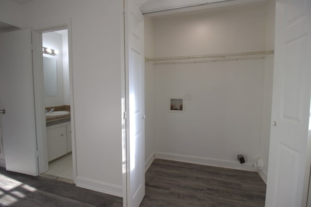 washroom featuring dark wood-style floors, washer hookup, a sink, laundry area, and baseboards