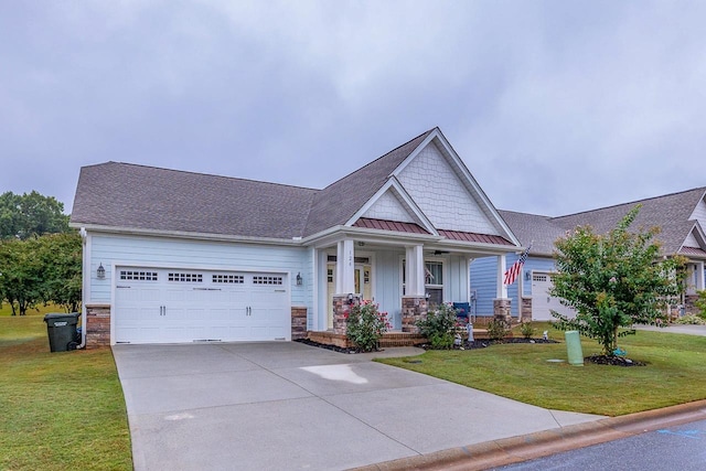 craftsman-style house featuring a porch, an attached garage, a standing seam roof, driveway, and a front lawn