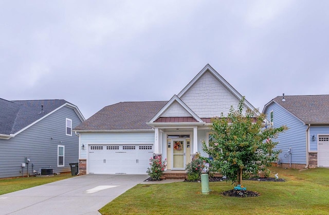 craftsman-style home featuring concrete driveway, an attached garage, a front lawn, and central AC unit