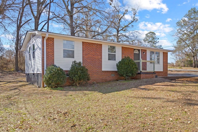 view of front of home with a front lawn, crawl space, and brick siding