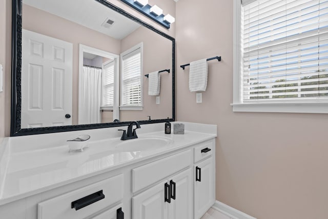 full bathroom featuring visible vents, vanity, a wealth of natural light, and baseboards