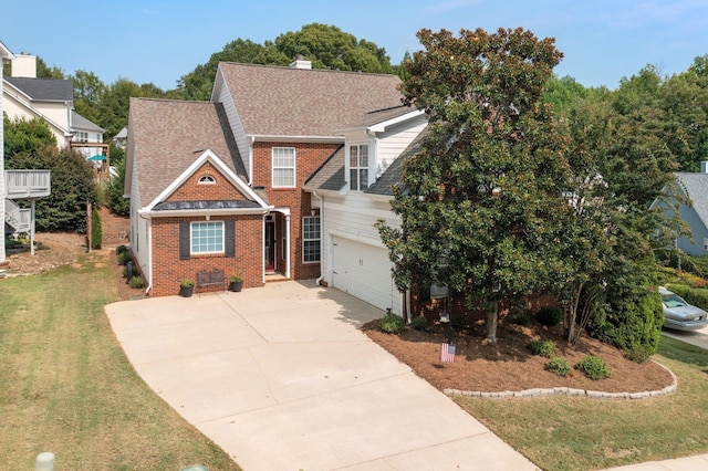 traditional-style home featuring brick siding, roof with shingles, a chimney, a front yard, and driveway