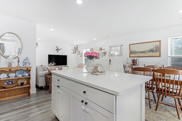 kitchen with light wood-style flooring, recessed lighting, white cabinetry, light countertops, and a center island