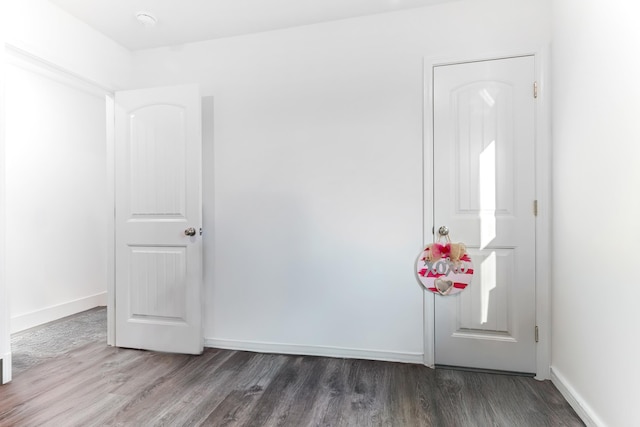 interior space with dark wood-type flooring and baseboards