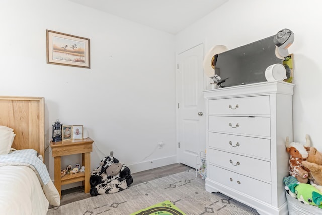 bedroom with light wood finished floors and baseboards