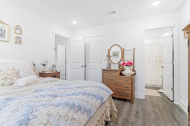 bedroom featuring recessed lighting, dark wood-type flooring, visible vents, baseboards, and ensuite bath