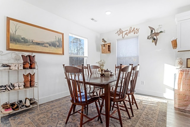 dining room featuring visible vents, baseboards, and wood finished floors