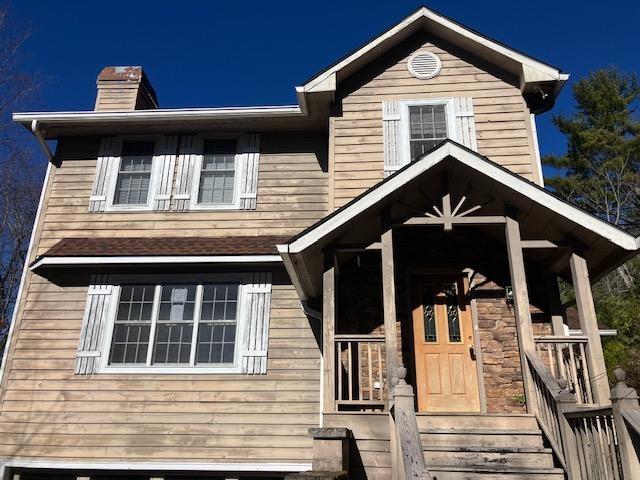 view of front of house with a porch and a chimney