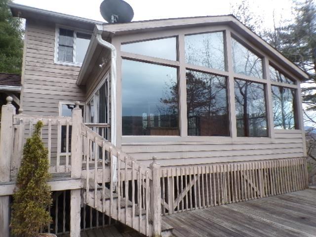 deck with stairway and a sunroom