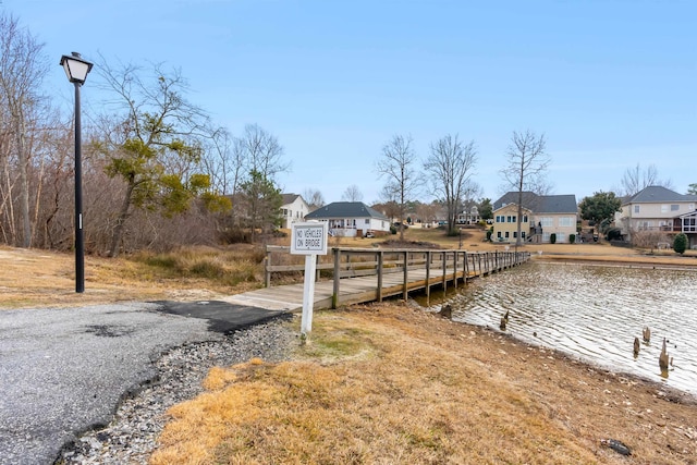 view of dock featuring a water view and a residential view