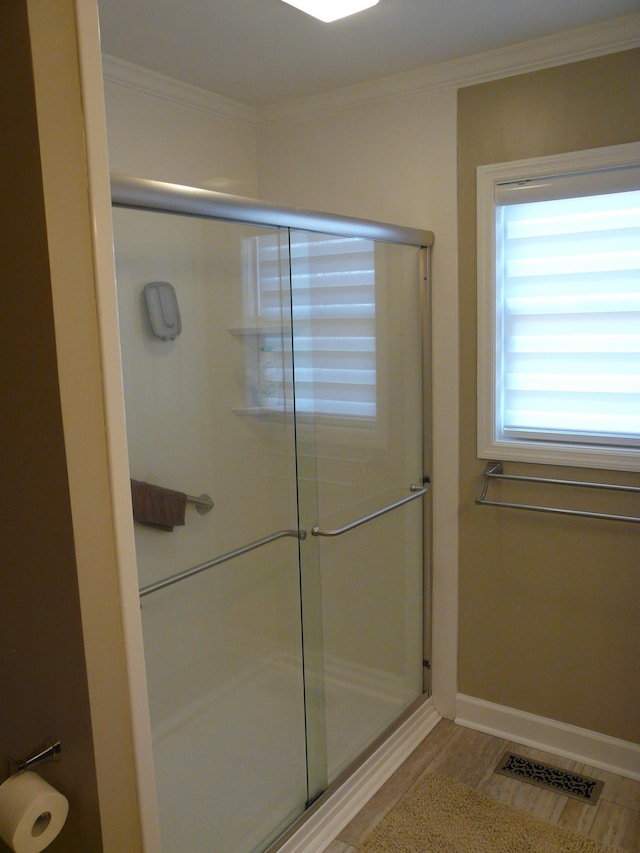 bathroom featuring baseboards, an enclosed shower, visible vents, and crown molding