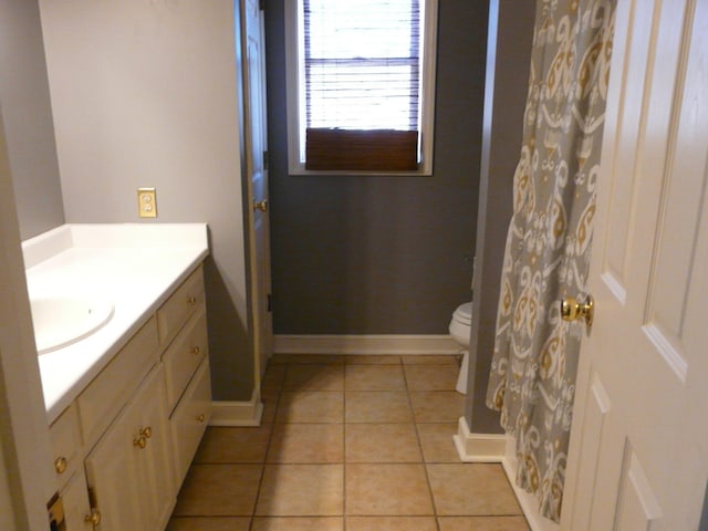 full bathroom with toilet, vanity, baseboards, and tile patterned floors