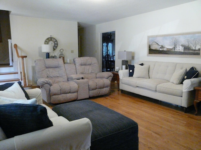 living area with stairway and wood finished floors