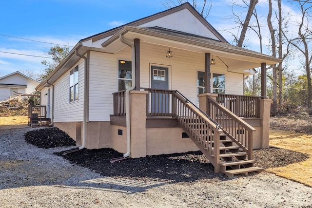 bungalow-style home featuring covered porch and stairway