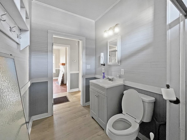 ensuite bathroom with crown molding, toilet, ensuite bathroom, vanity, and wood finished floors