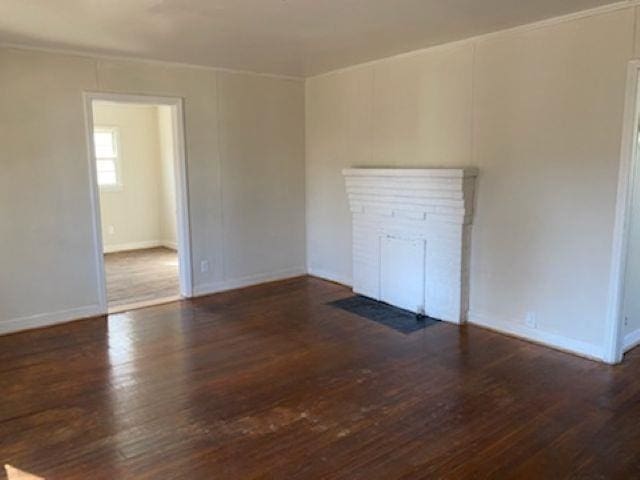 unfurnished room featuring dark wood-type flooring and baseboards