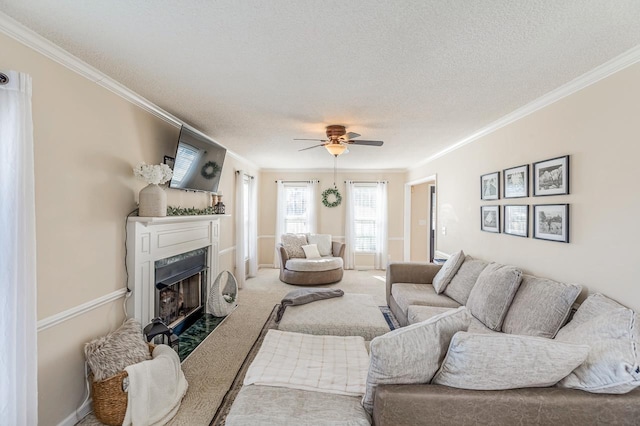 carpeted living room featuring ornamental molding, a fireplace, a textured ceiling, and a ceiling fan