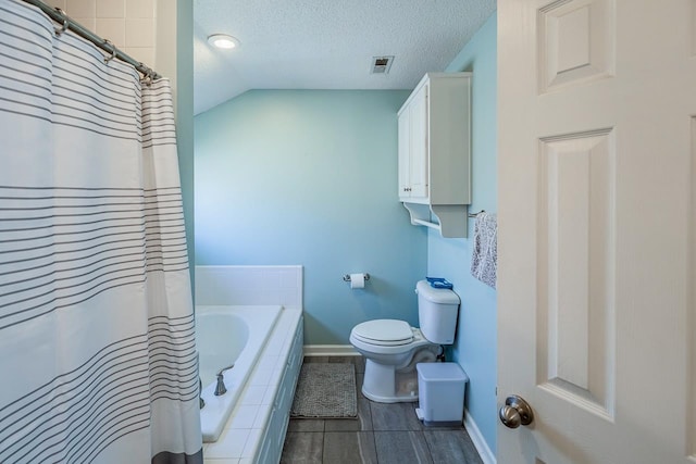 bathroom with a textured ceiling, lofted ceiling, visible vents, baseboards, and tiled tub