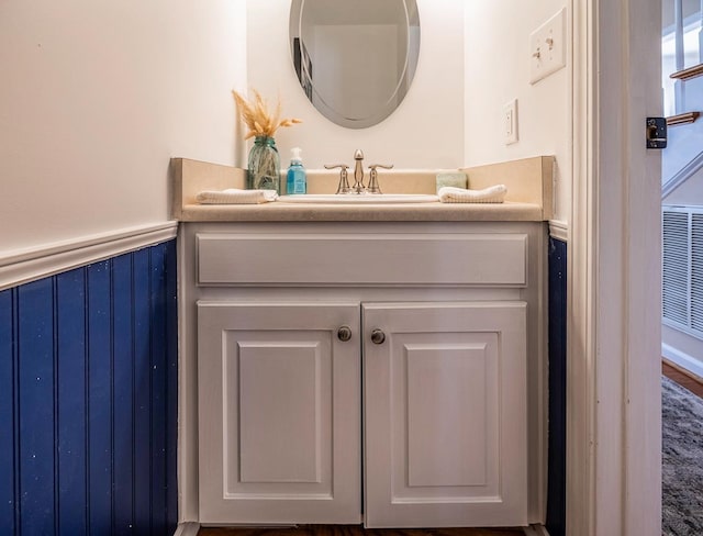 bathroom featuring a wainscoted wall and vanity