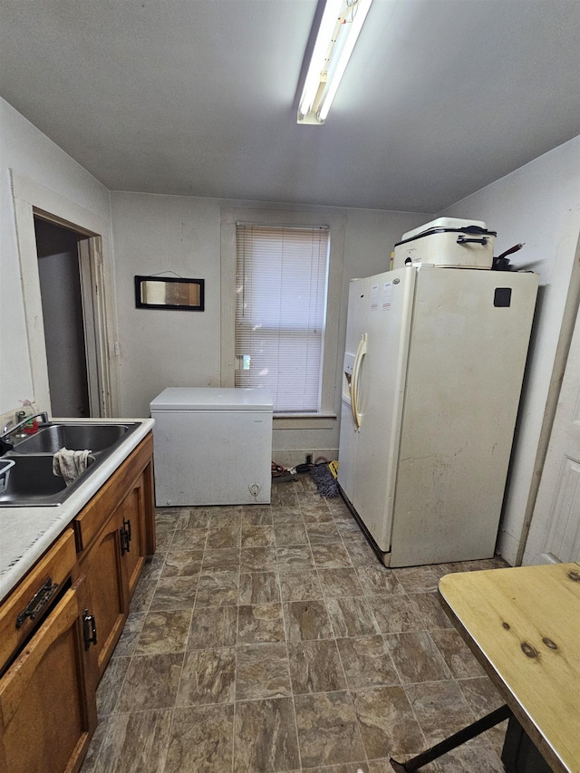 laundry area featuring stone finish floor and a sink