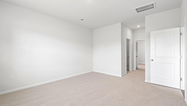 empty room featuring light colored carpet, baseboards, and recessed lighting