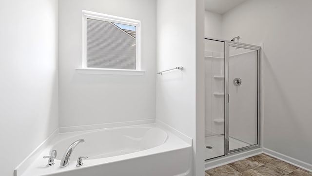 bathroom with a shower stall and a bath
