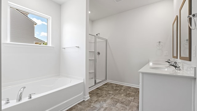 bathroom with a stall shower, a bath, baseboards, and double vanity