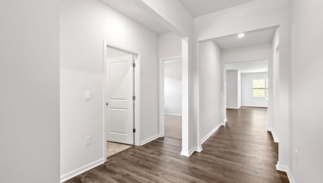 hall featuring dark wood-style floors and baseboards