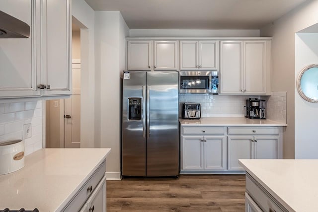 kitchen with appliances with stainless steel finishes, light countertops, and white cabinets