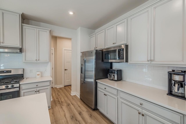 kitchen featuring light countertops, appliances with stainless steel finishes, and under cabinet range hood