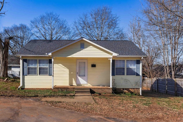 view of front of house featuring fence and roof with shingles