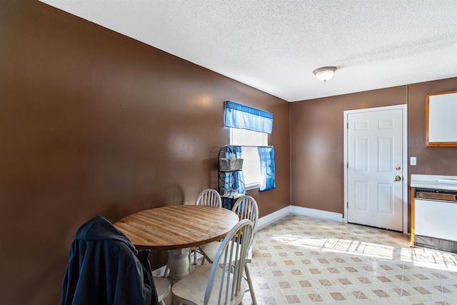 dining space with a textured ceiling and baseboards