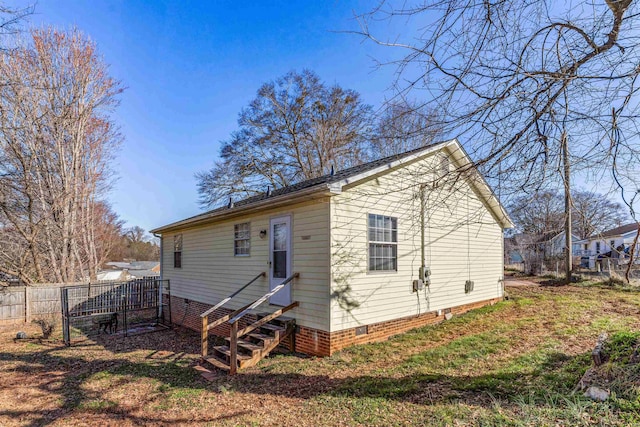 back of property featuring entry steps, crawl space, and fence