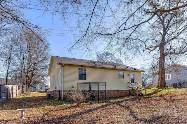 back of property with entry steps, crawl space, fence, and central AC unit